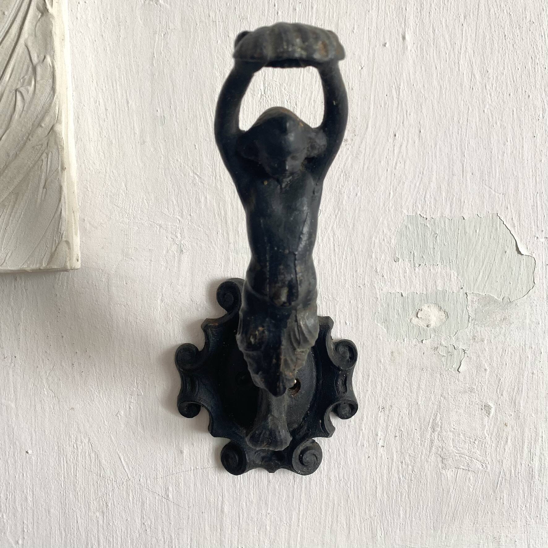 Antique cast iron coat hook with swimmer and shell basin.