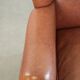 Fauteuil anglais à oreilles de couleur cognac clair en cuir de vache.