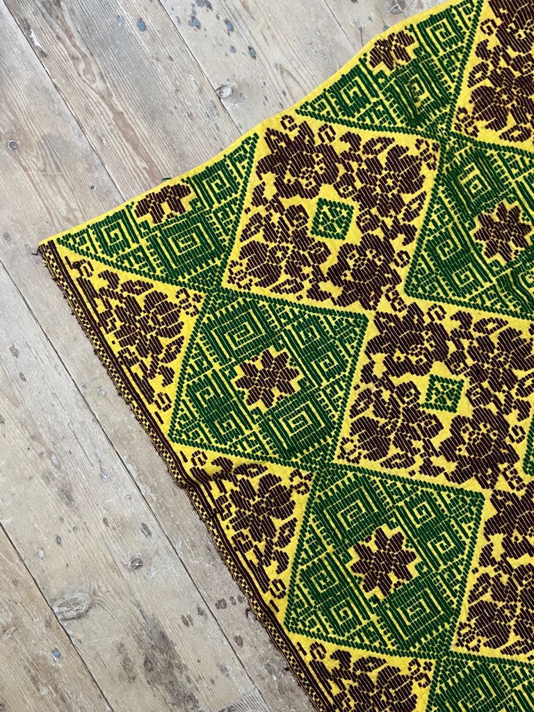 Green and yellow handmade rug with delicate colourful flowers
