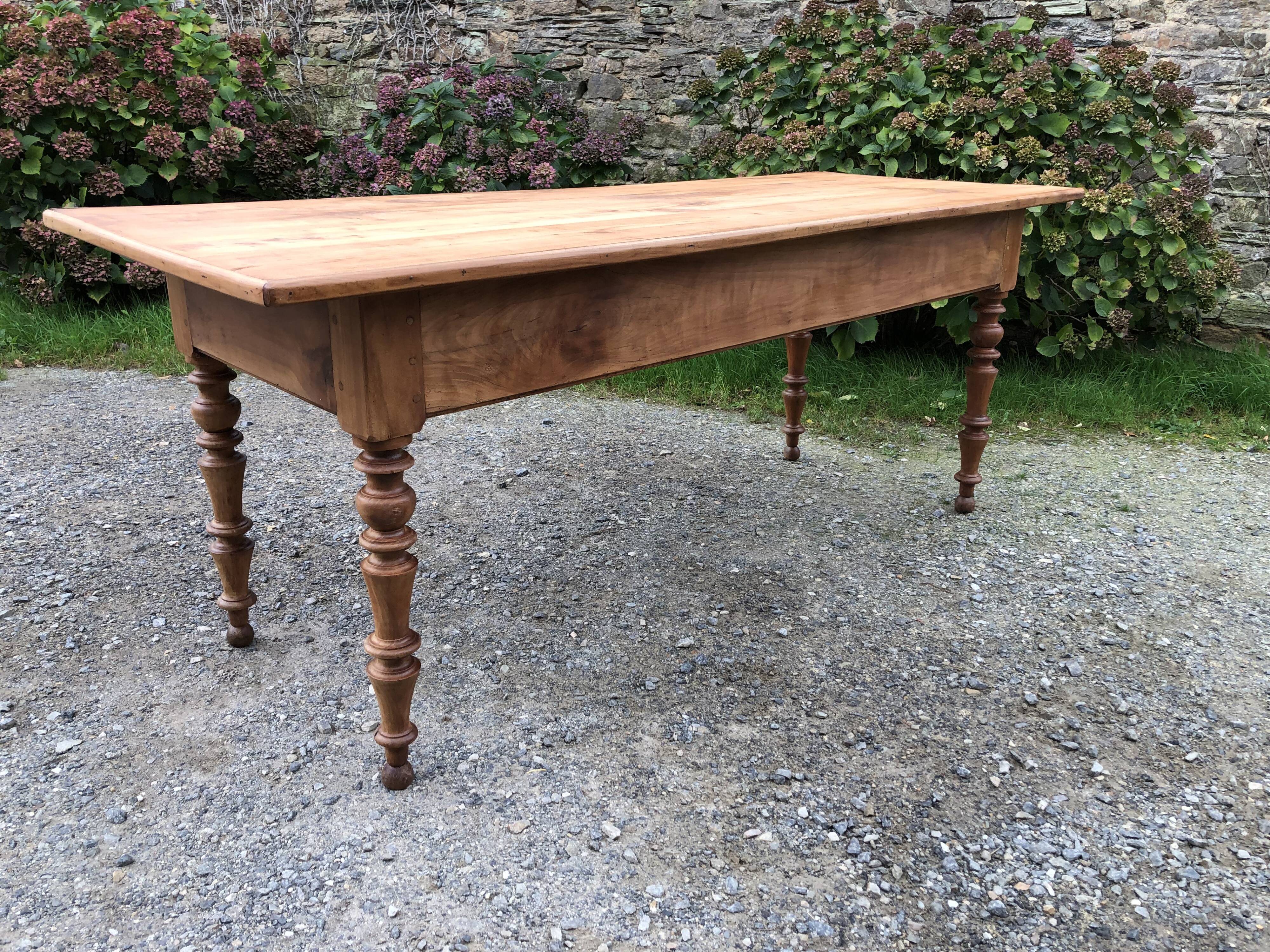 Antique Louis Philippe style farm table in solid cherry wood with 2 drawers and turned base.
