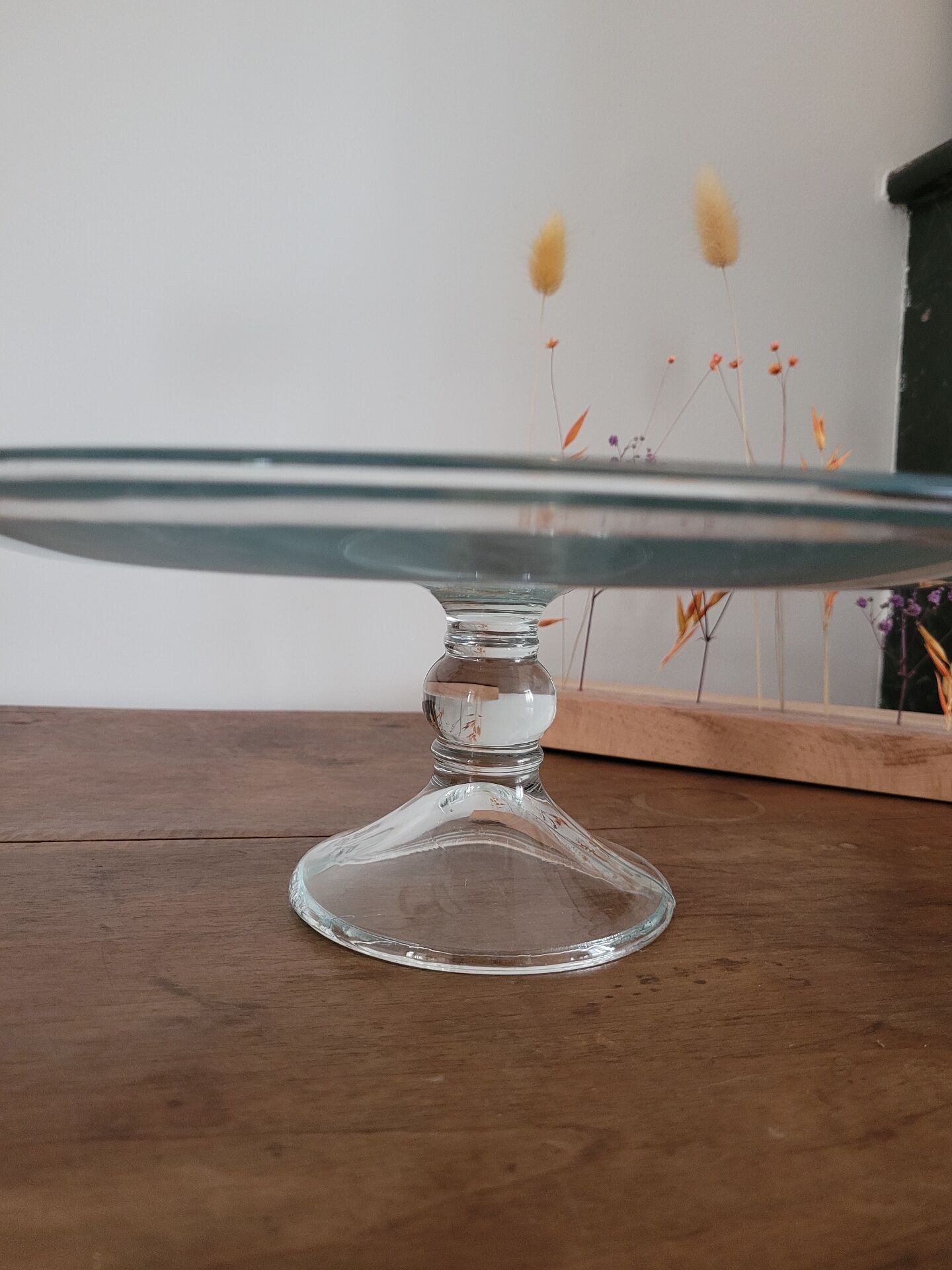 Large glass display plate mounted on a stand.