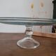 Large glass display plate mounted on a stand.