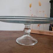 Large glass display plate mounted on a stand.
