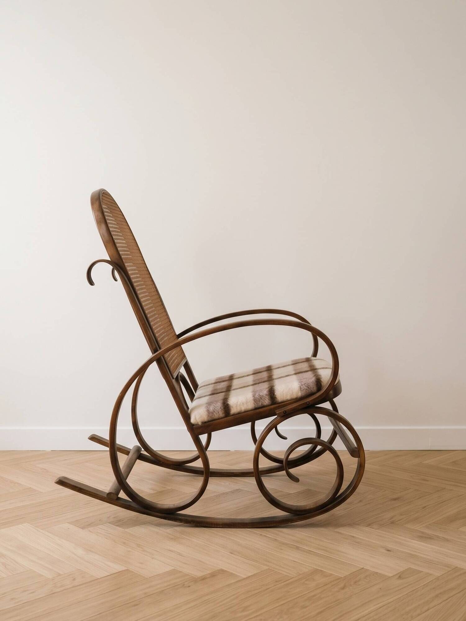 Antique rocking chair in curved wood and caning.