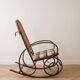Antique rocking chair in curved wood and caning.