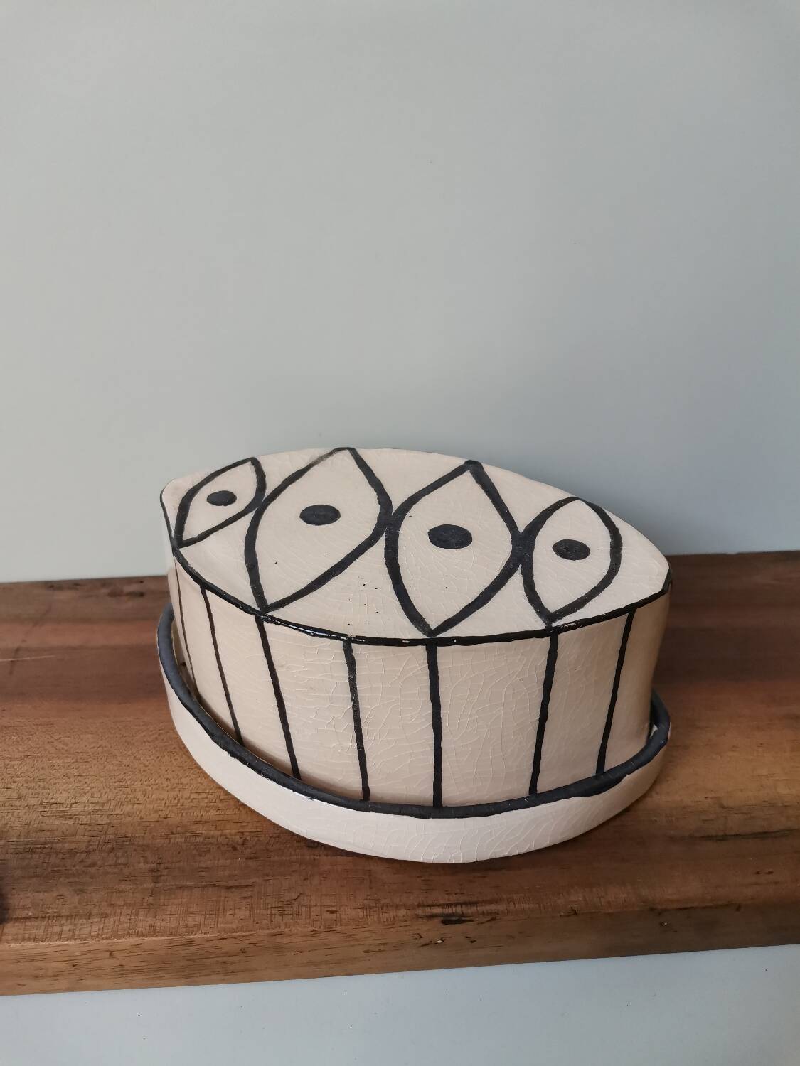 Vintage artisanal rustic ceramic butter dish with geometric eye pattern