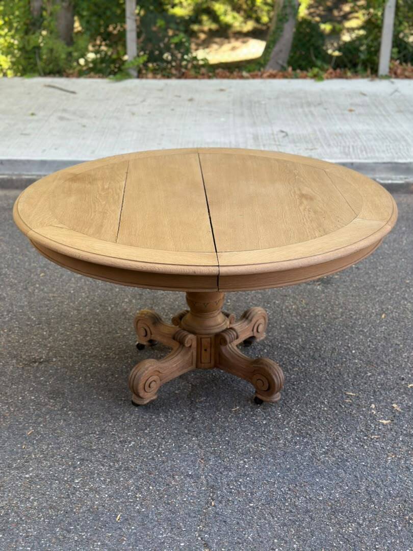 Round dining table with a central pedestal, stripped raw oak, 4 extensions, 19th century.