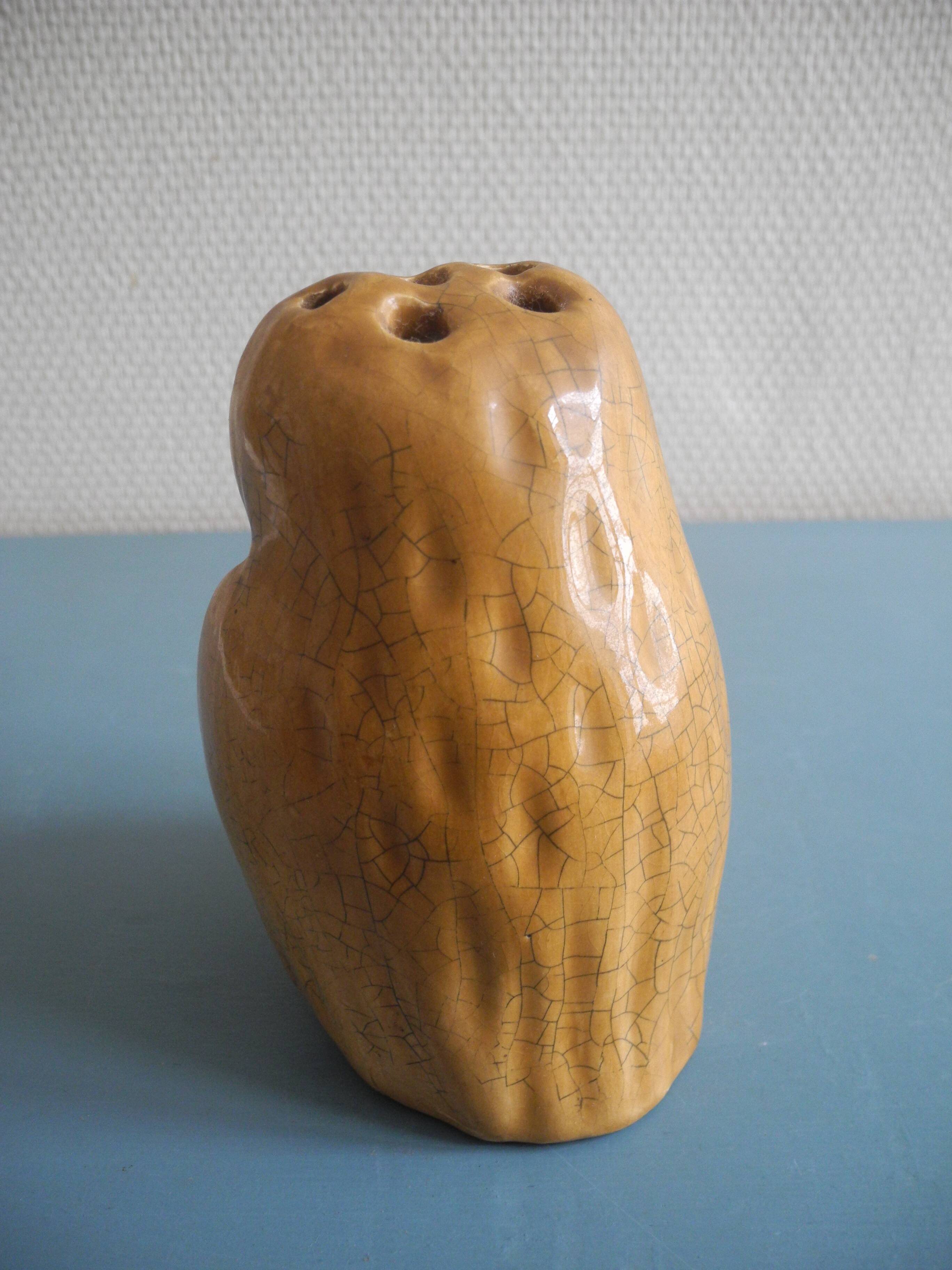 vintage earthenware vase with an old flower pick and an owl decoration