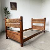 Brutalist style bed with chain and straw