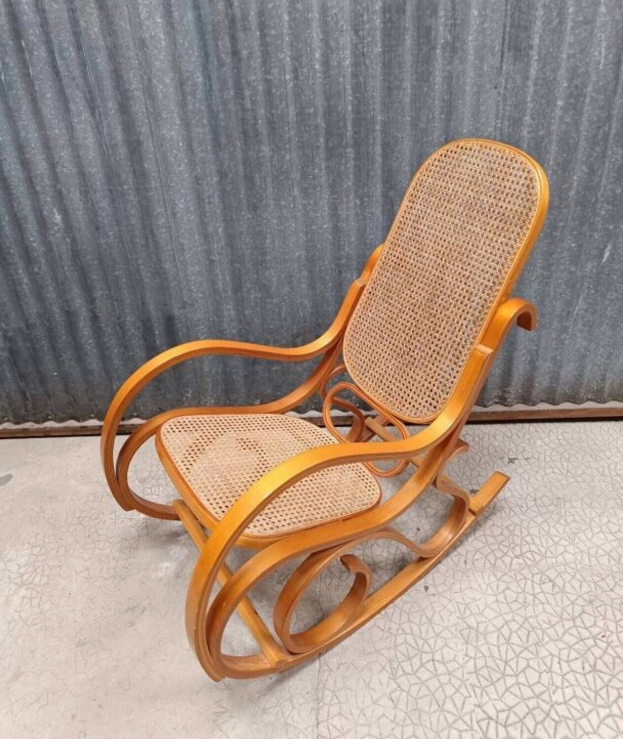 Curved wooden rocking chair with wicker cane rattan.
