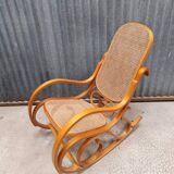 Curved wooden rocking chair with wicker cane rattan.