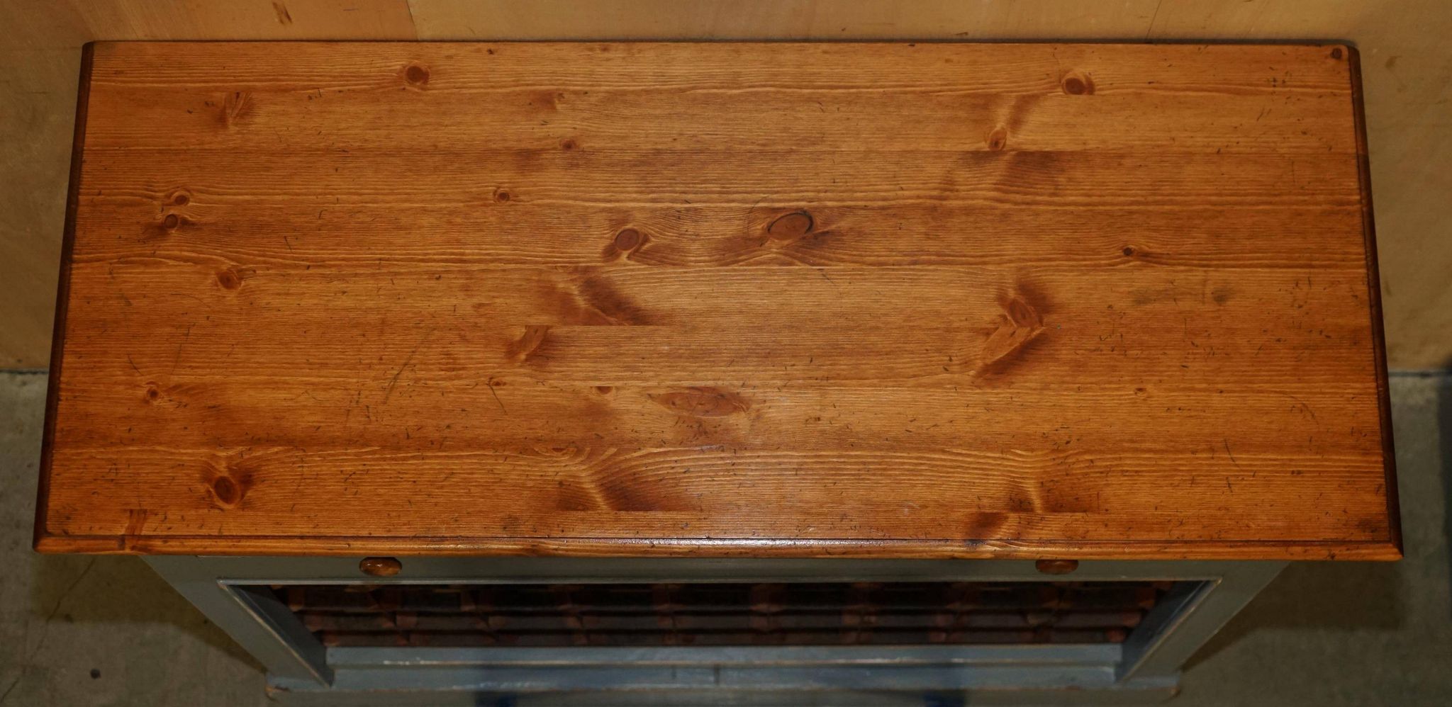 Vintage wooden furniture for 45 wine bottles with a drawer.