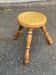 Vintage low tripod stool with carved light oak legs.