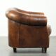 Fauteuil club en cuir de peau de mouton avec un coussin de siège fixe.