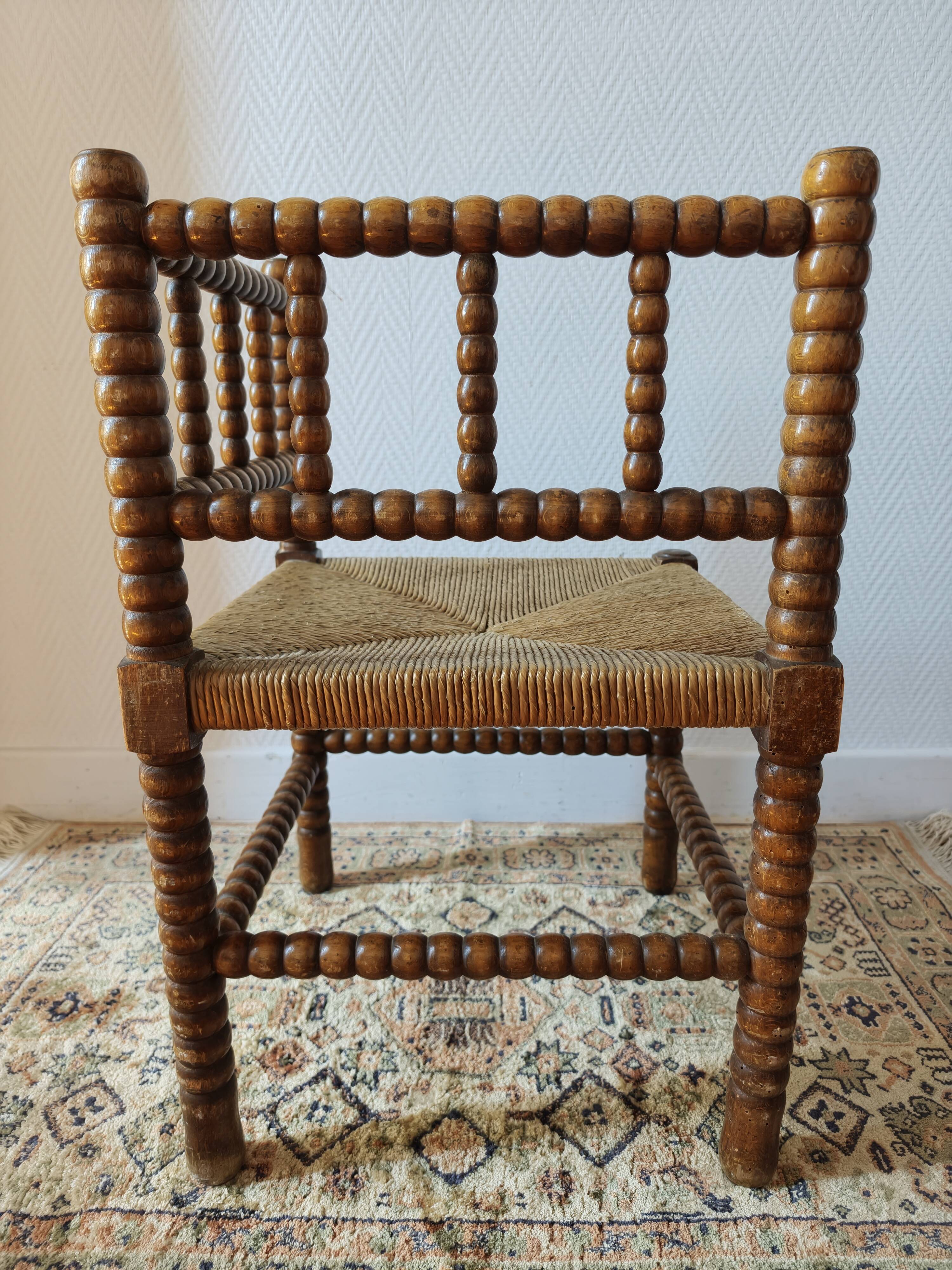 Antique corner chair by the fire with turned wood and straw seat.