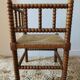 Antique corner chair by the fire with turned wood and straw seat.