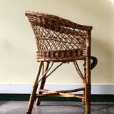 Woven rattan armchair with armrests.