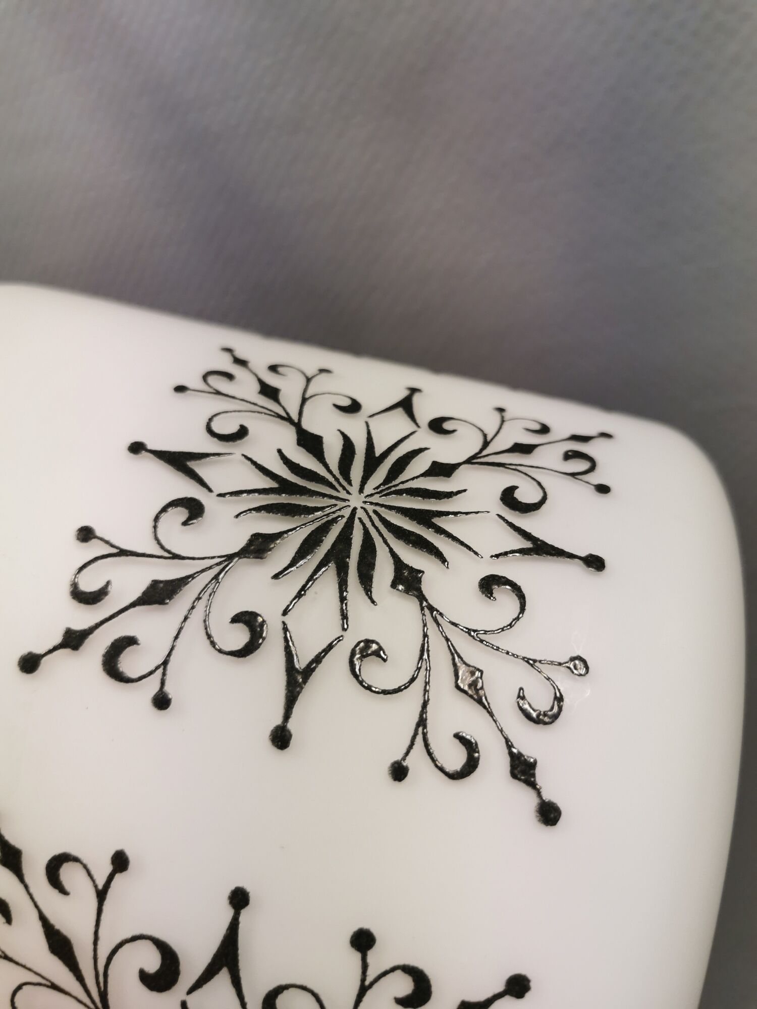 Scandinavian hanging lamp in white glass with inlayed black motifs.
