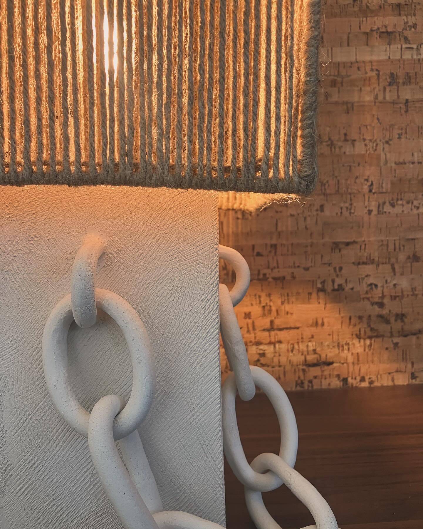 Table lamp in ceramic with decorative chain and cord shade.