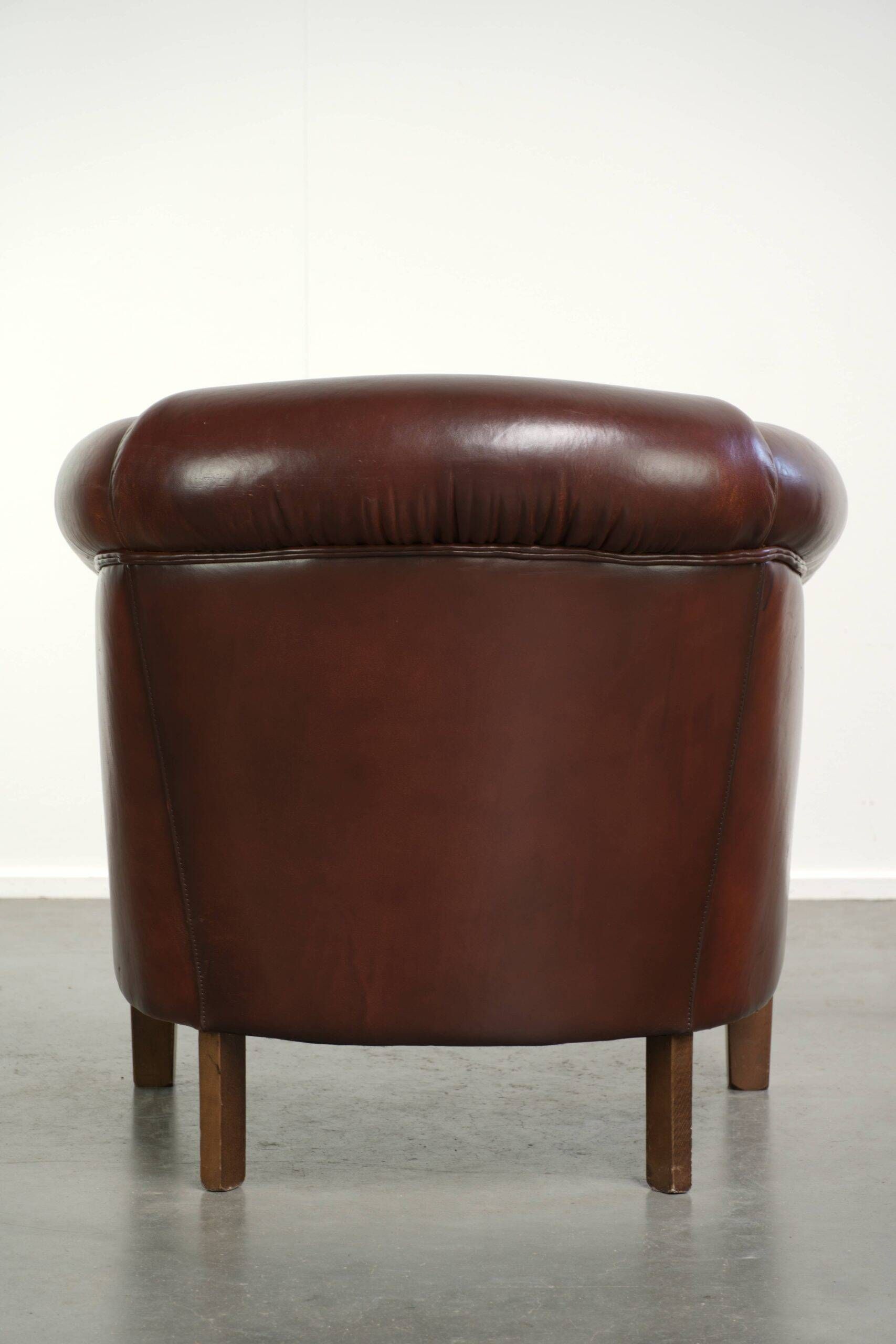 Characterful sheepskin club armchair in a dark cognac colour in English style