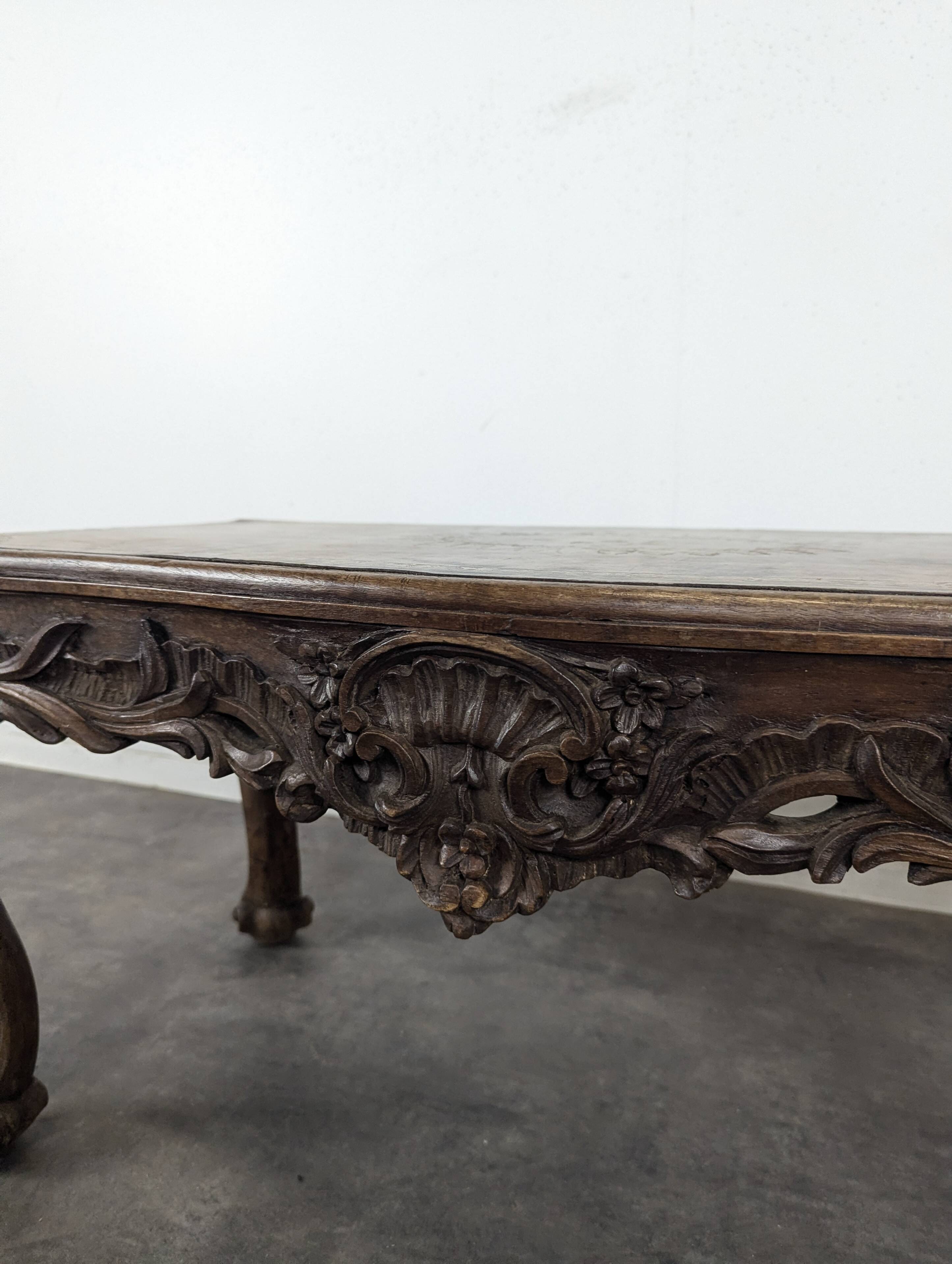 Louis XV coffee table in carved walnut with a gilded leather top.
