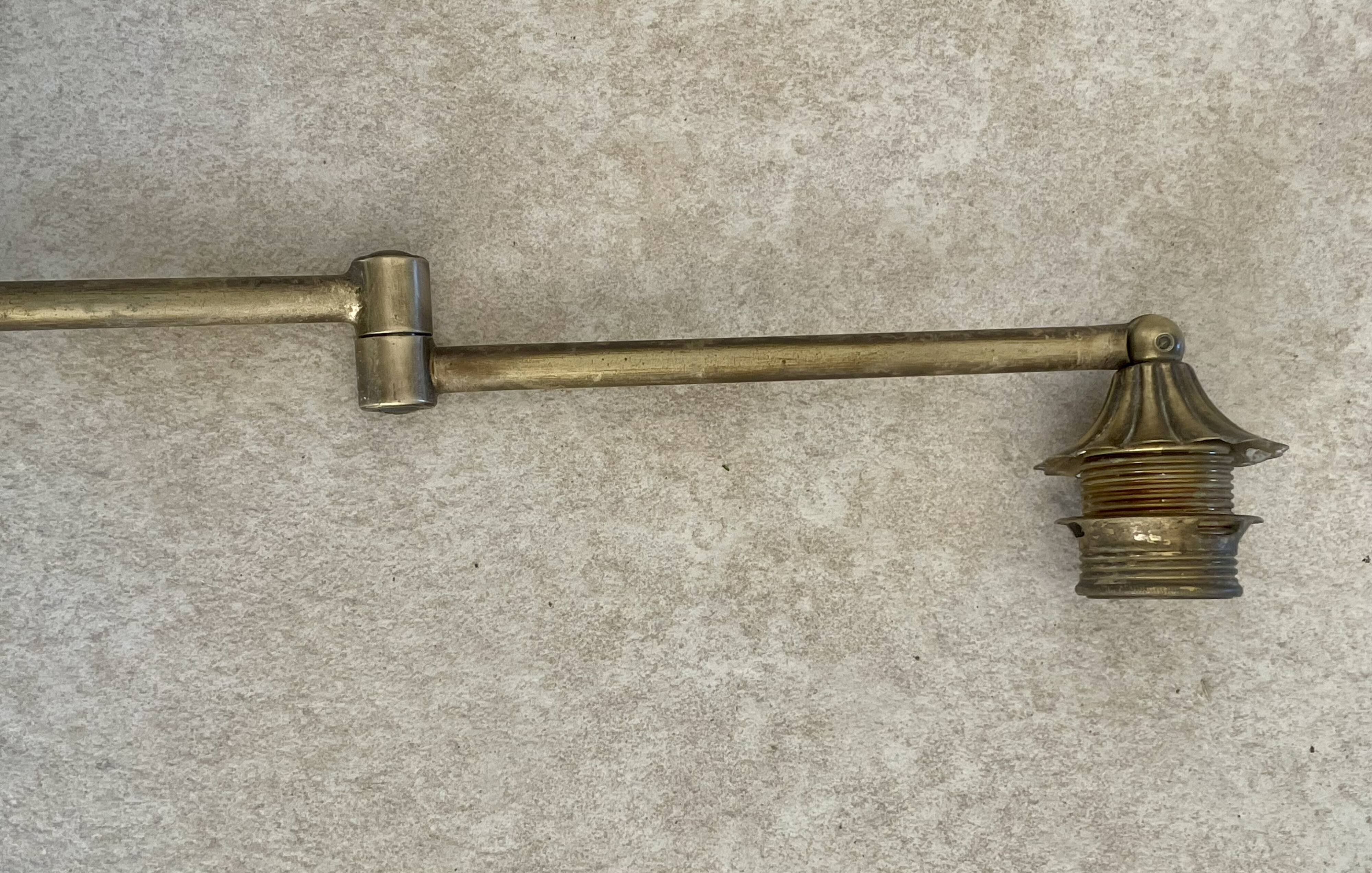 Adjustable wall light in brass and gold metal.