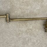 Adjustable wall light in brass and gold metal.