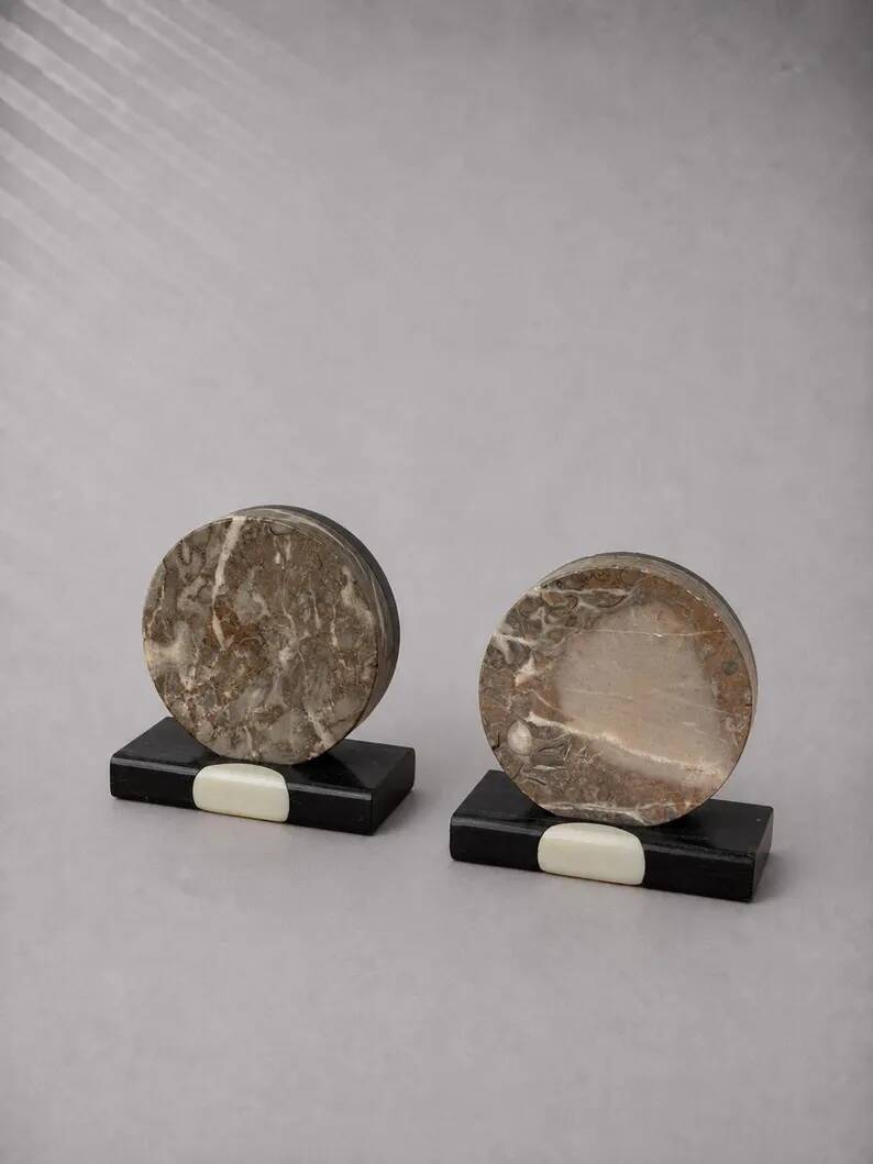 Vintage pair of bookends in fossilised coral agate | Stone disc-shaped bookends on a black marble base