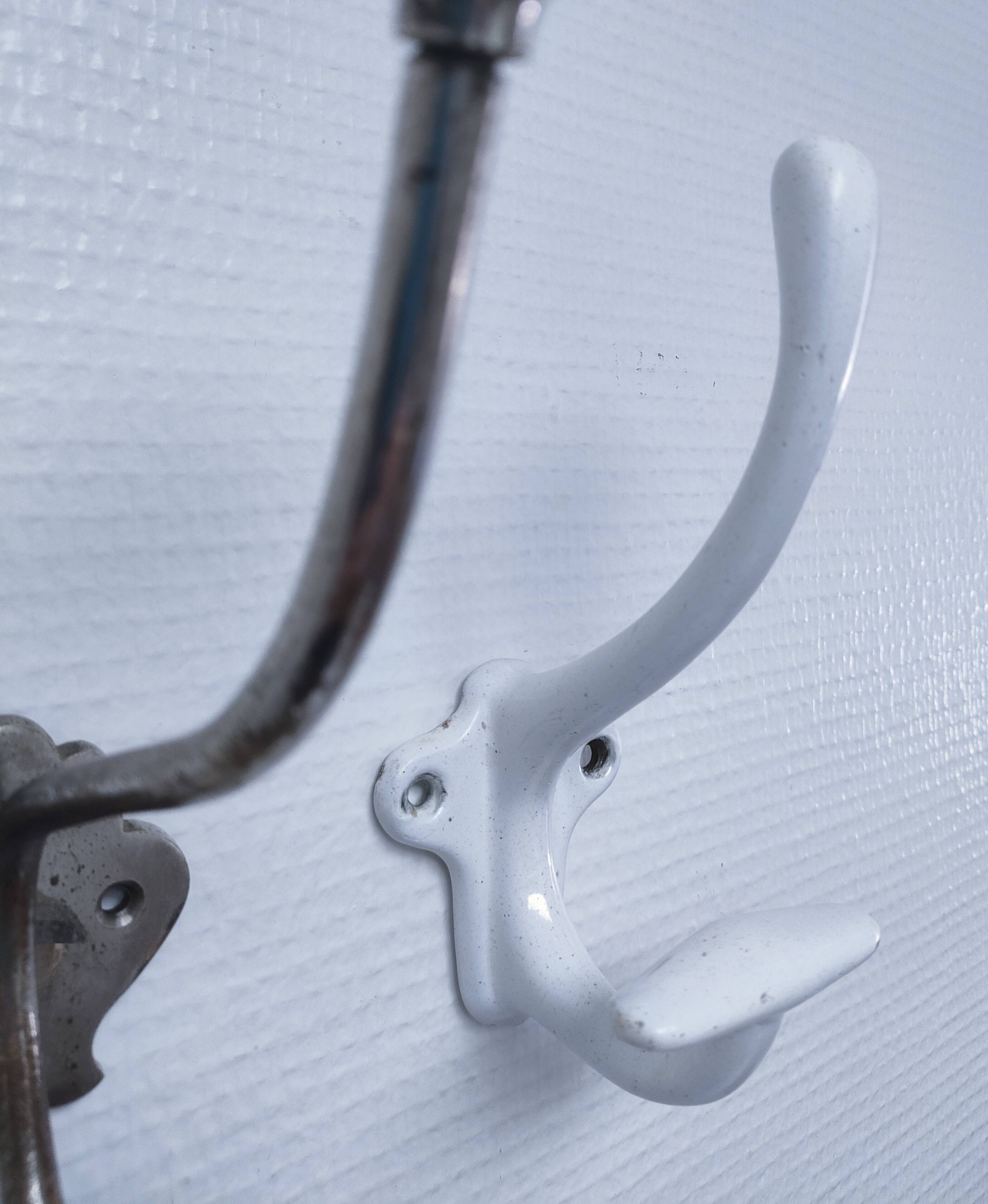 Three enameled cast iron coat hooks and vintage patina metal