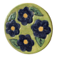Round trivia decorated with blue flowers on a green background.