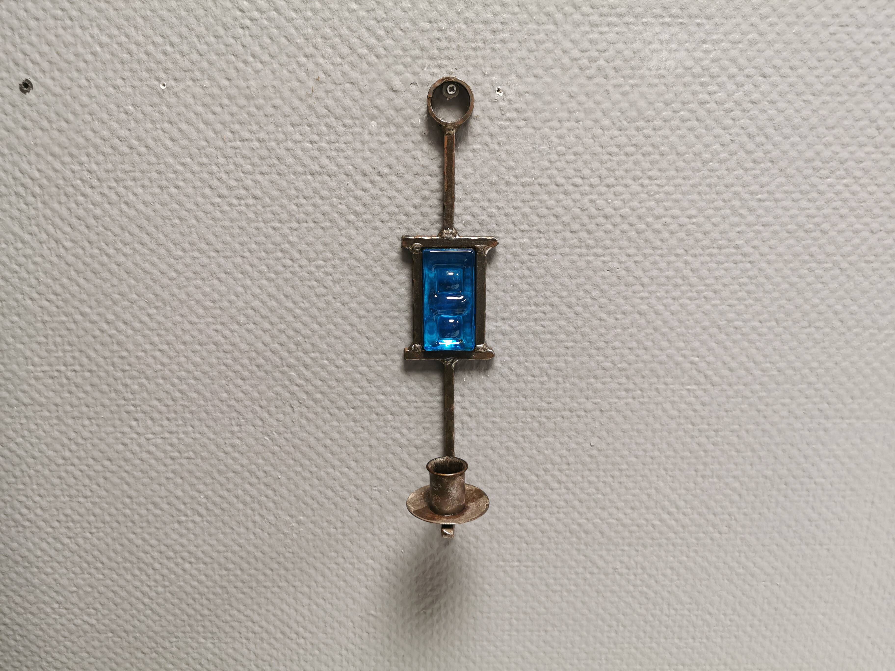 Wall-mounted candle holder in cast iron and hard pressed blue glass.