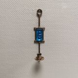 Wall-mounted candle holder in cast iron and hard pressed blue glass.