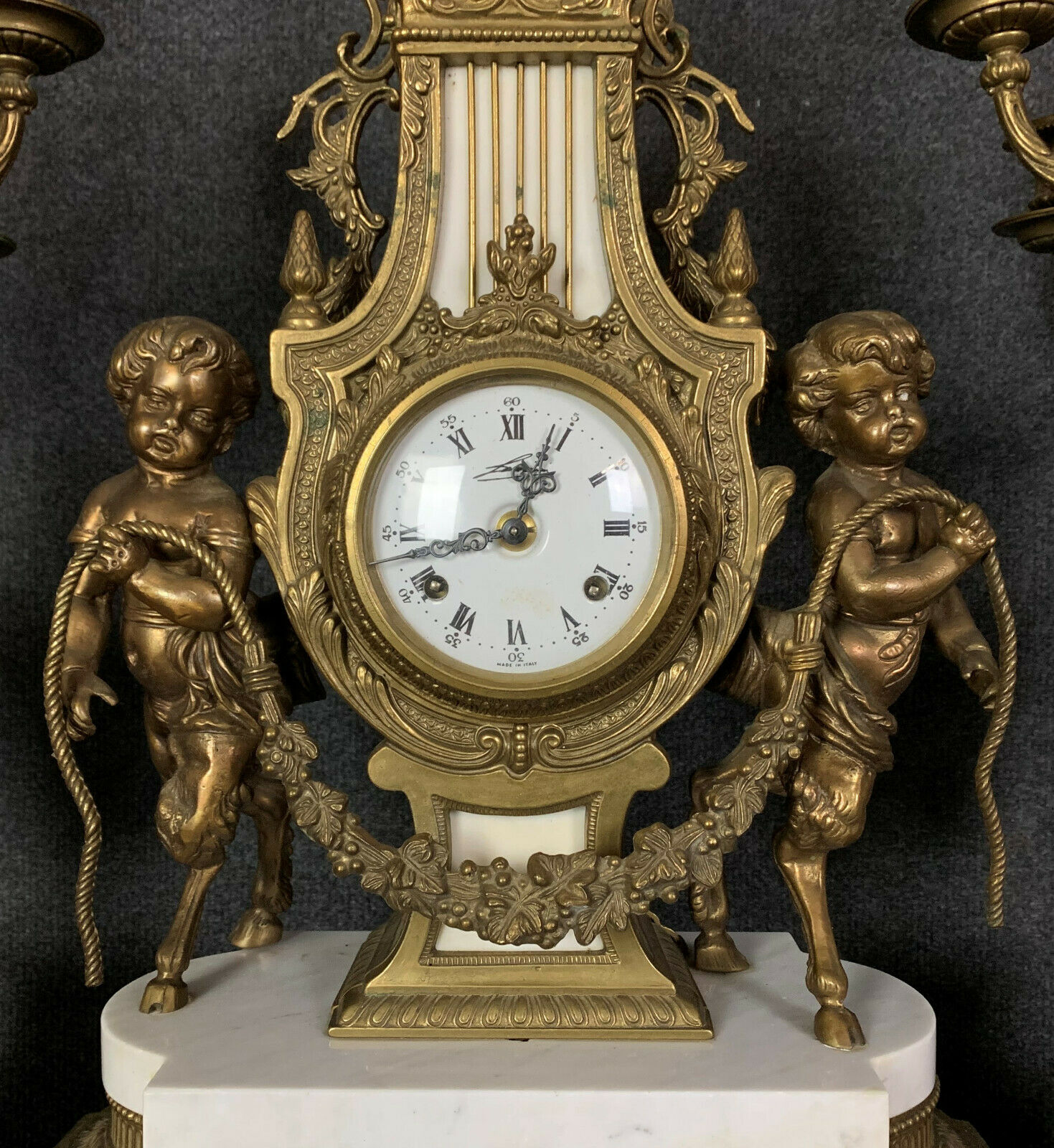 Pendule triptyque aux "Amours de Bacchus" en bronze a patine brune.