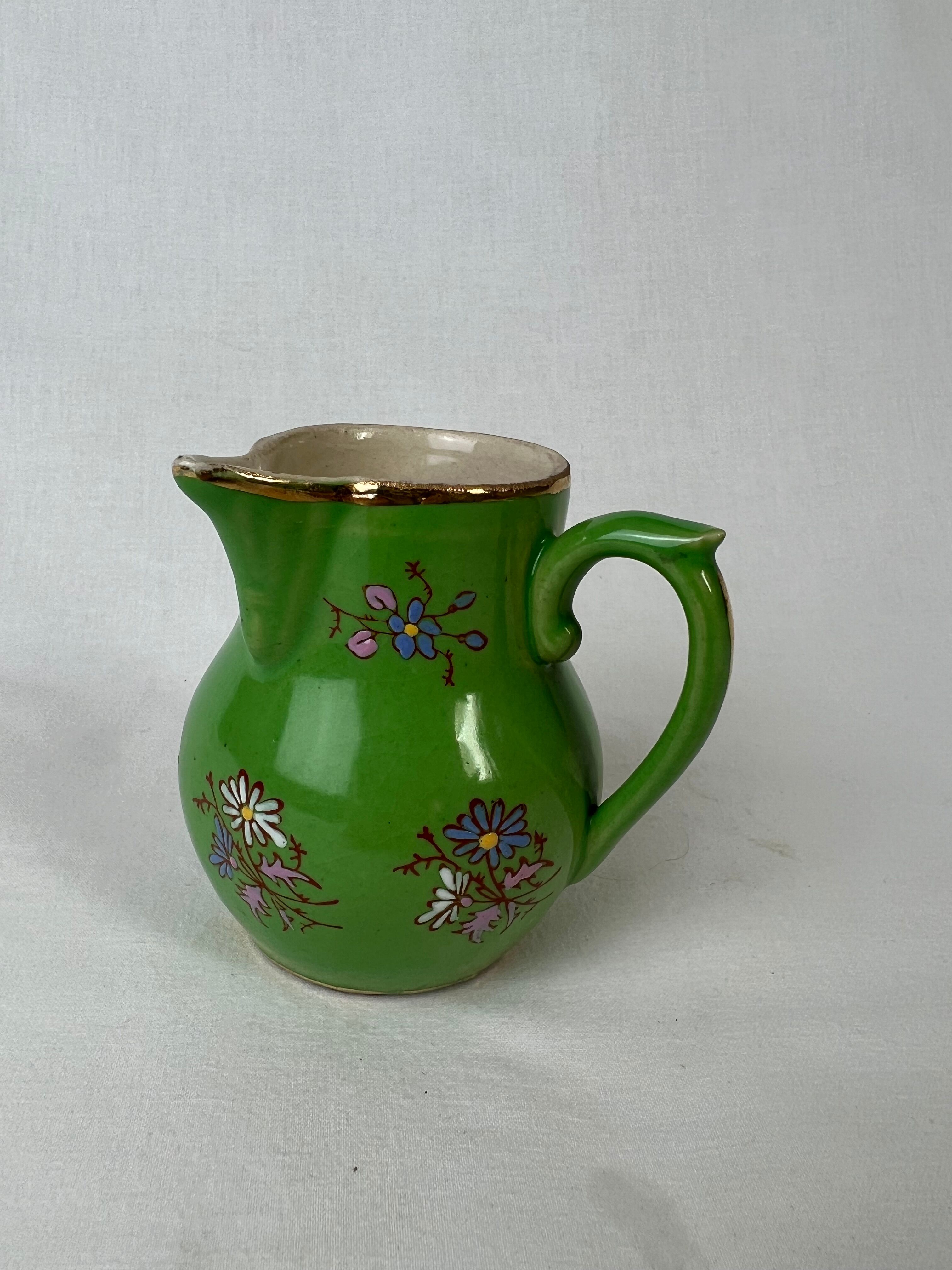 Green milk jug with enamelled flowers