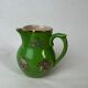 Green milk jug with enamelled flowers