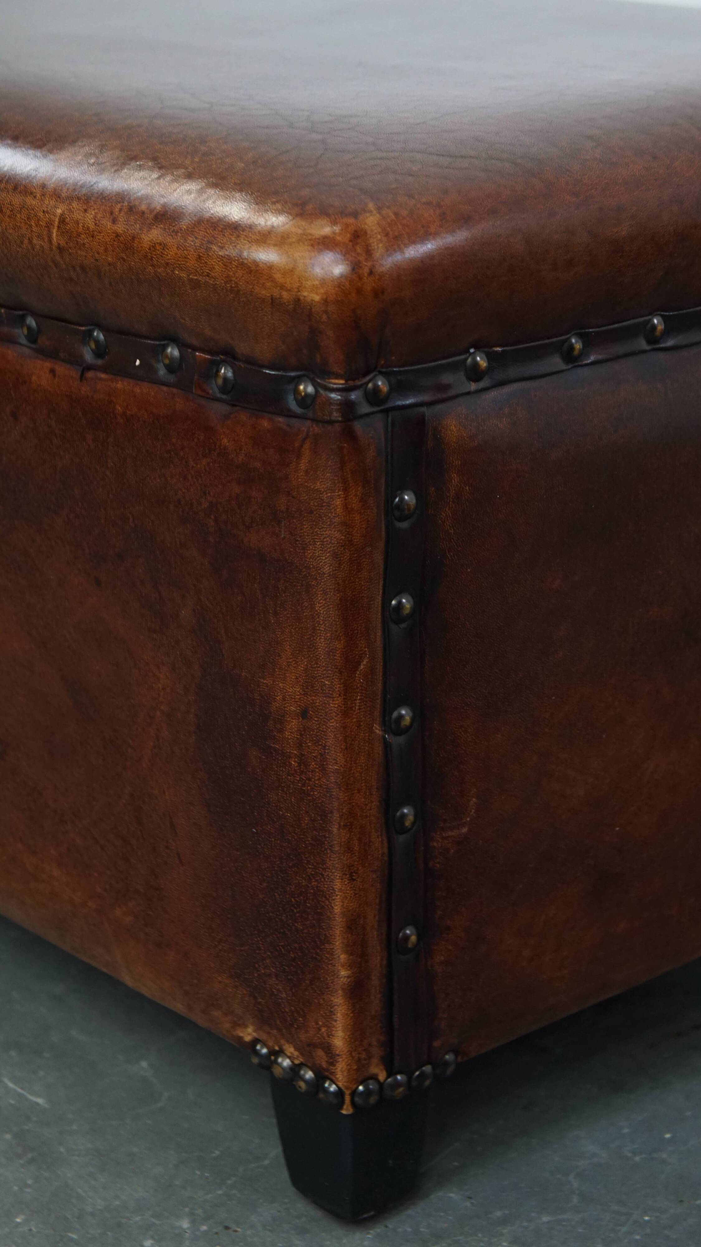 Cognac-colored sheepskin stool with decorative studs