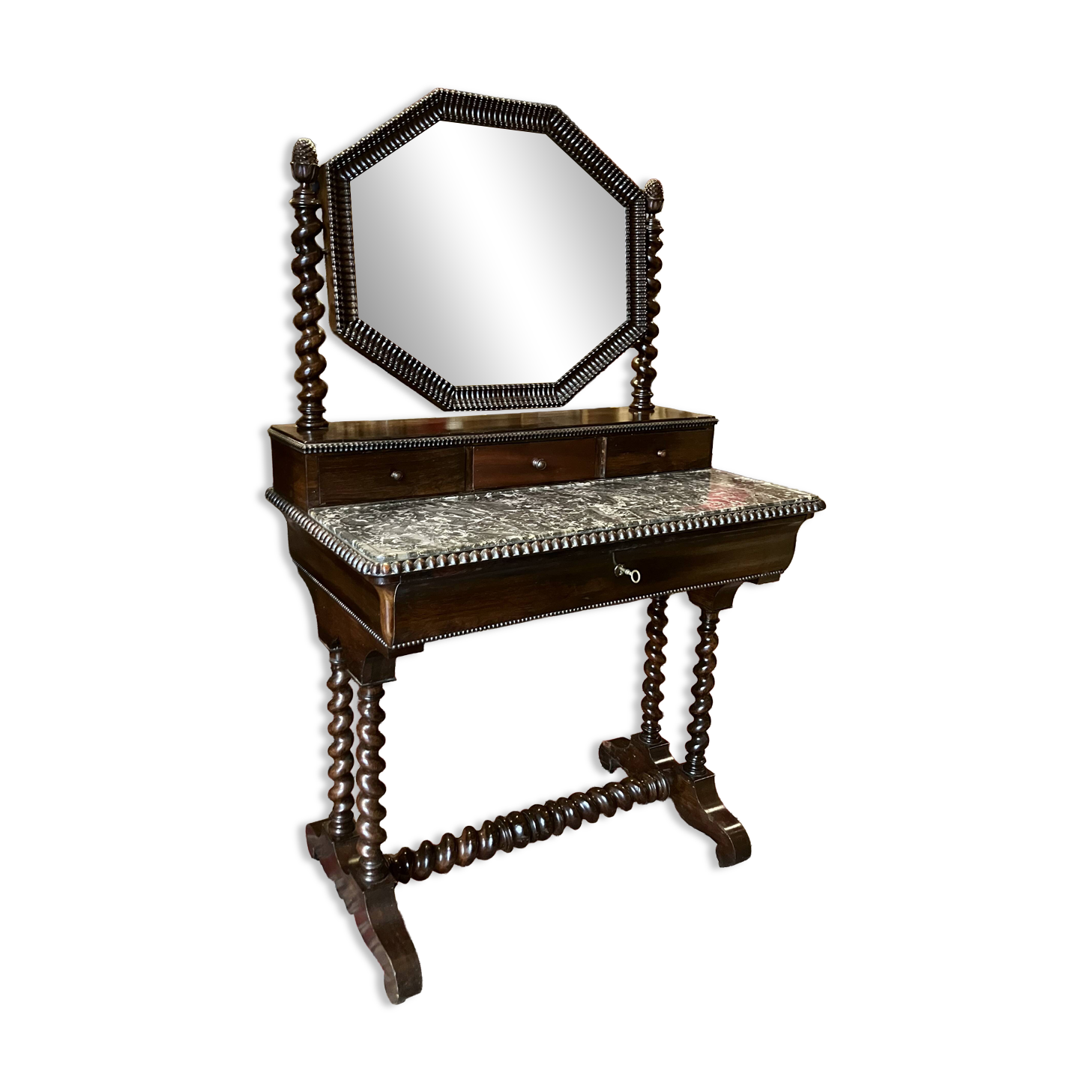 Antique English mahogany dressing table with carved details, black marble, and mirror.
