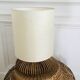 Table lamp with rattan base and papier-mâché hat