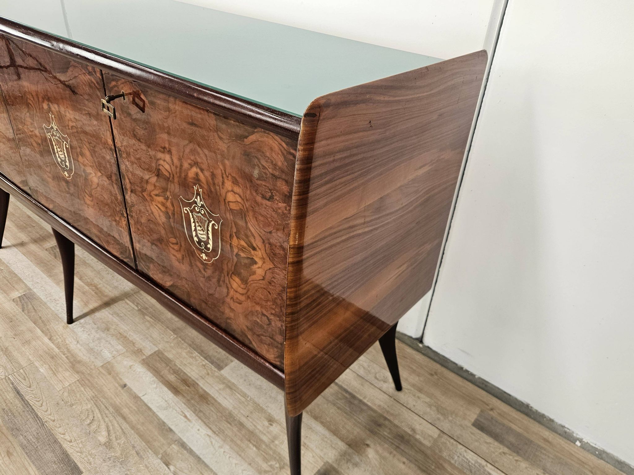 Mid-century mahogany buffet with teal glass and compartments with a drawer.