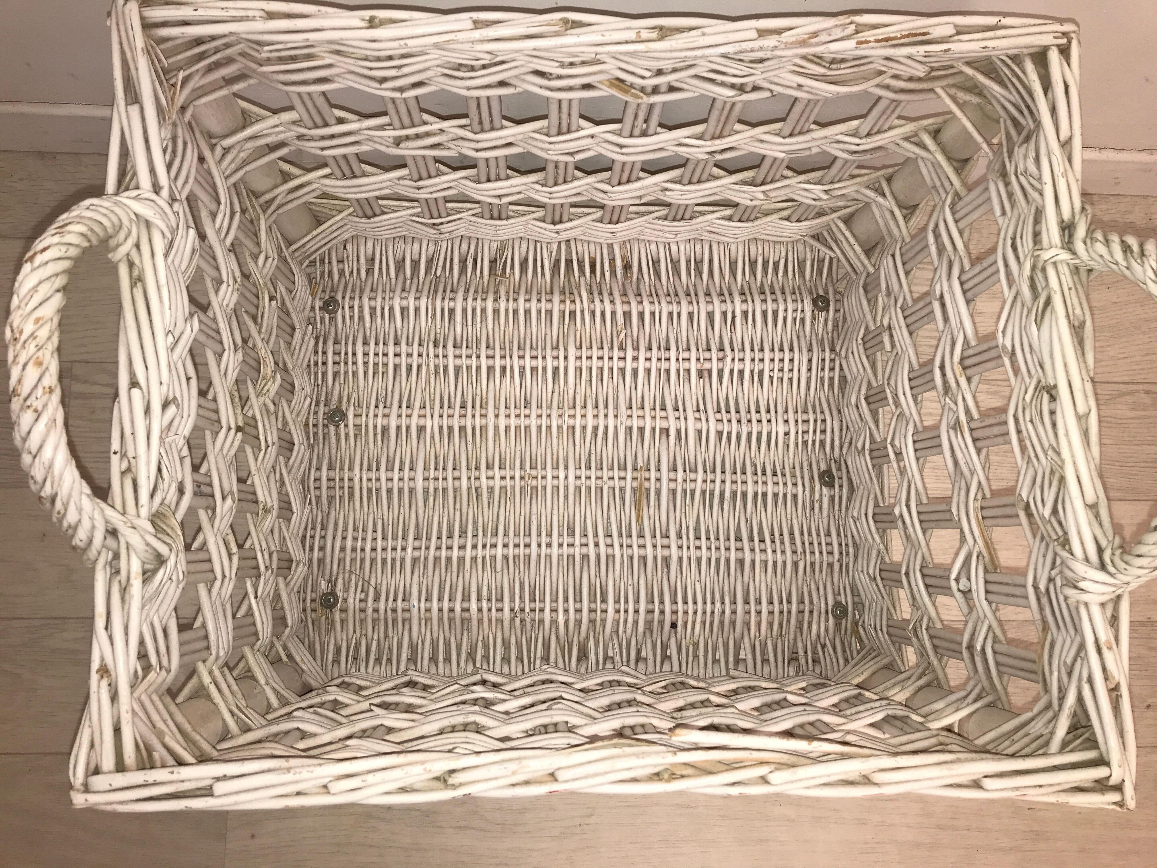 Wicker laundry basket on vintage wooden wheels