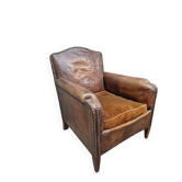 Antique club chair in patinated brown leather, English style, early 20th century.