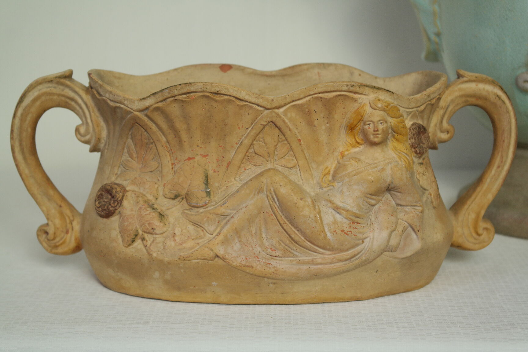 Art Nouveau jardinière with bas-reliefs in terracotta.