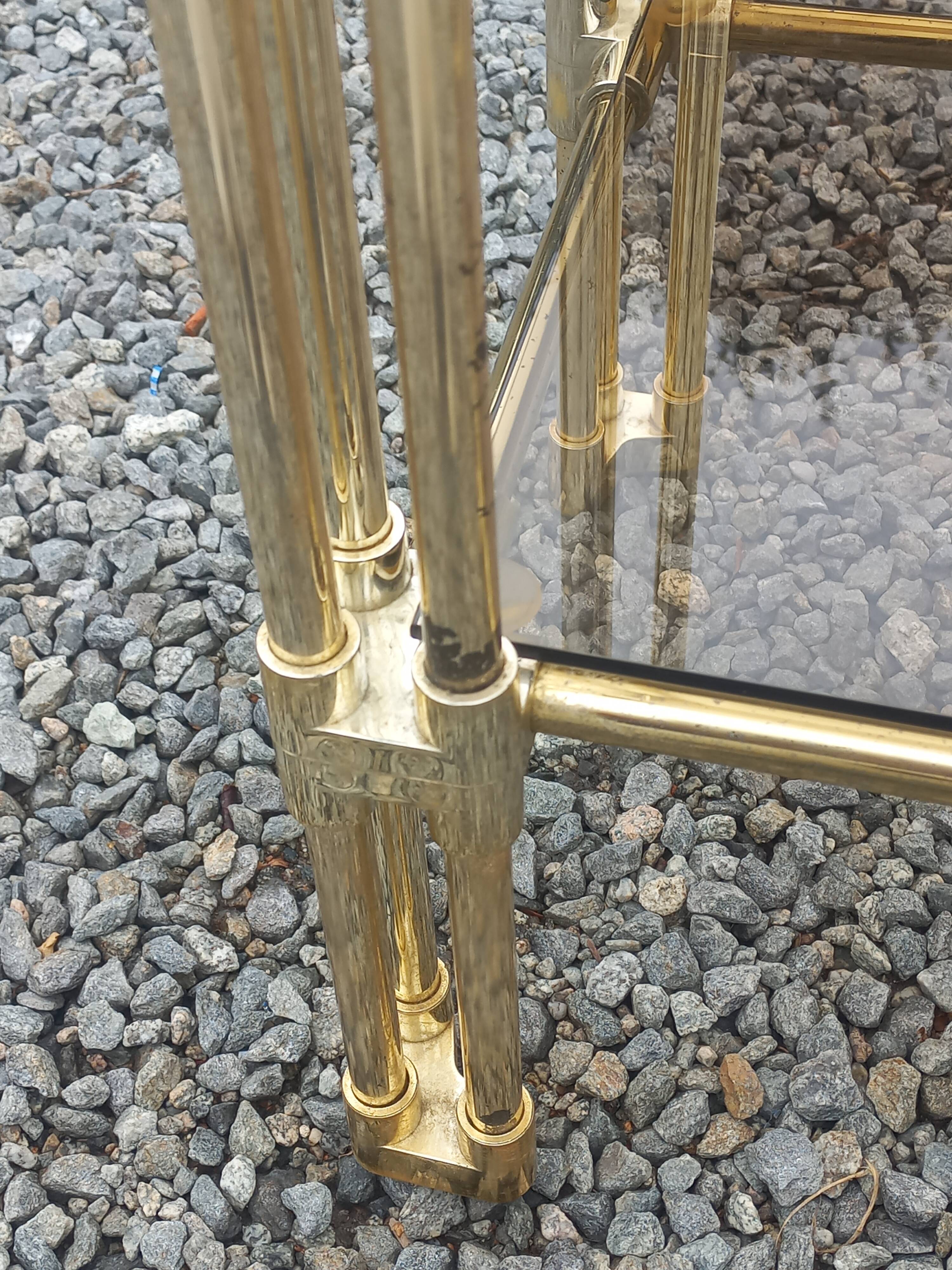 Pair of Hollywood Regency side tables in gold metal and smoked glass.