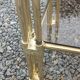 Pair of Hollywood Regency side tables in gold metal and smoked glass.