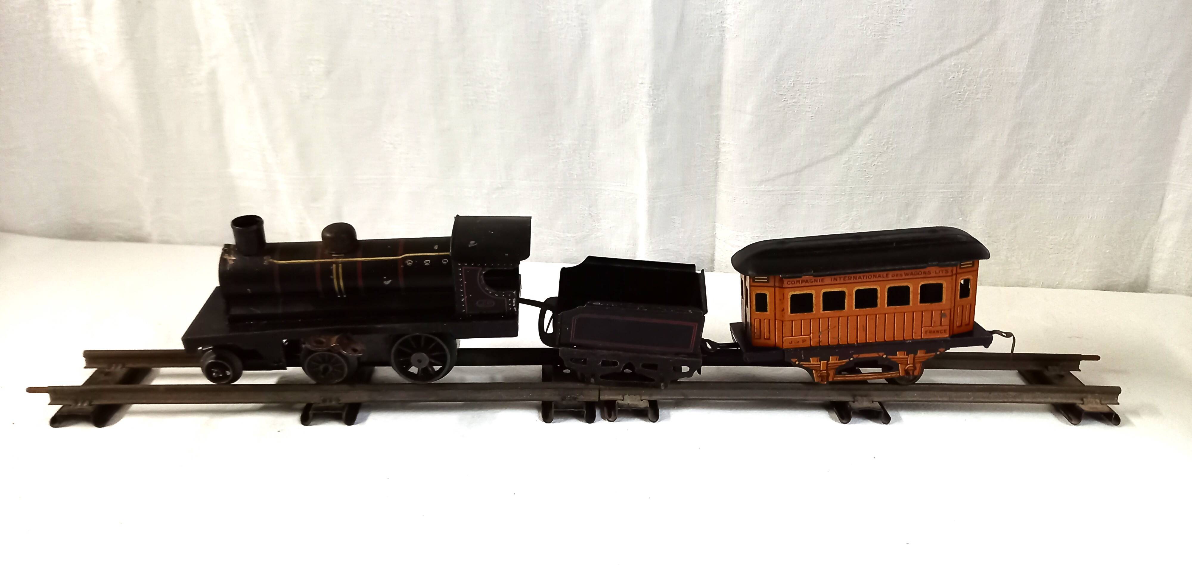 Small JEP mechanical train, including locomotive, tender, sleeping car, rail, 1930s