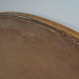 Old oval beveled wooden mirror, partly gilded and carved