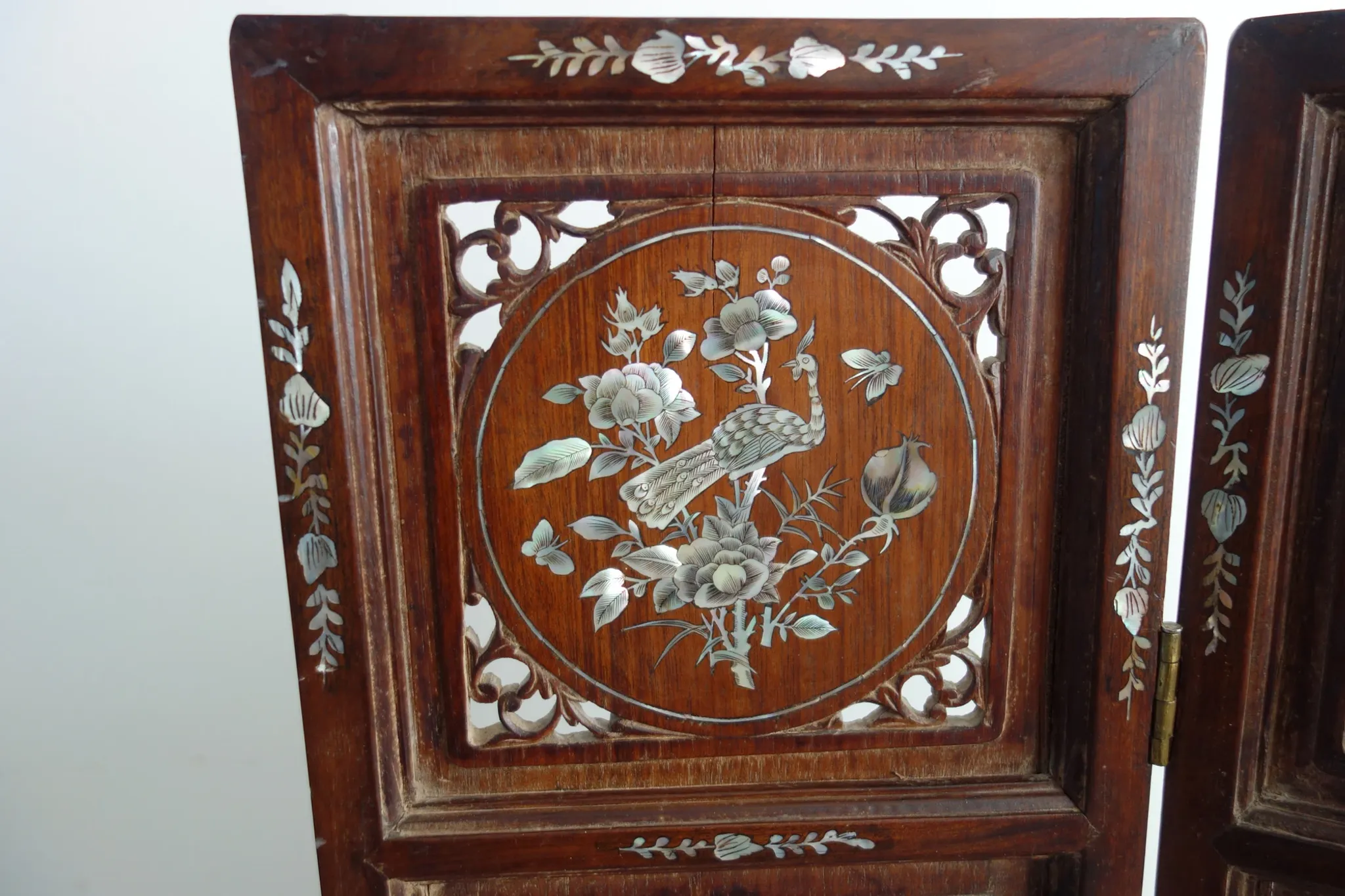 Asian screen in carved wood and mother-of-pearl marquetry.
