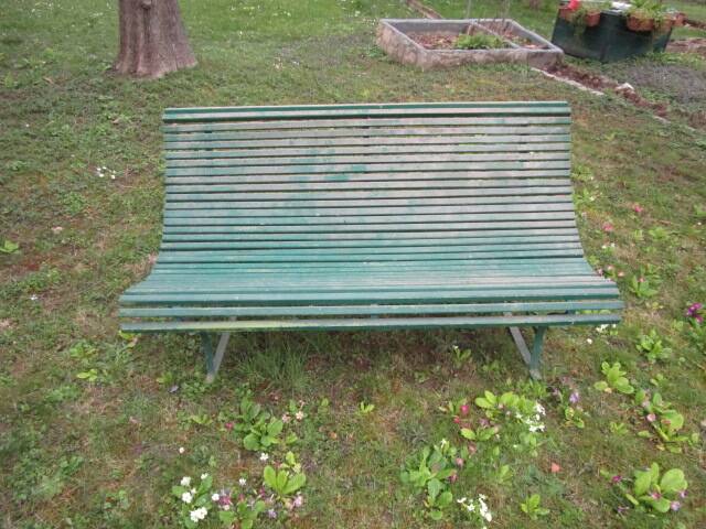 Old metal garden bench with wooden slats