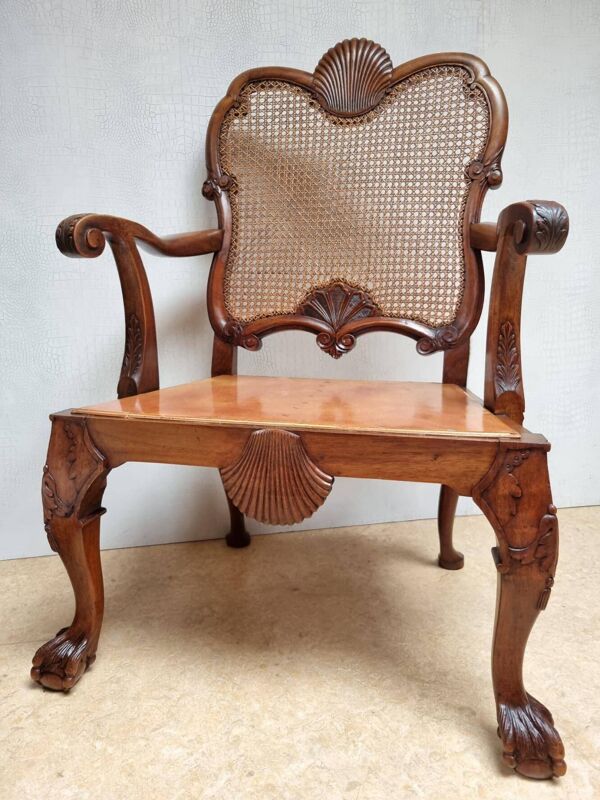 Fauteuil Bergère Chippendale, en acajou sculpté avec cannage et pieds en forme de griffes de lion.