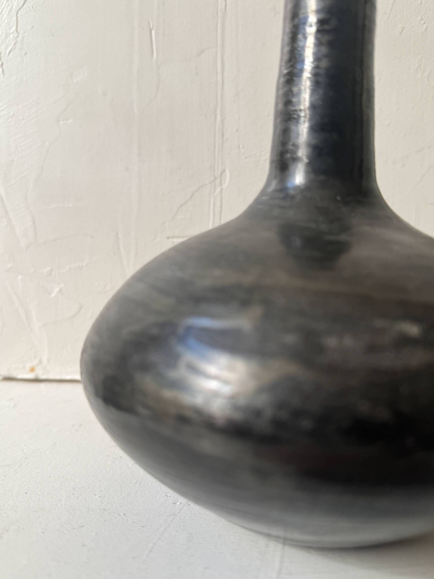 Glazed black ceramic vase with a single stem, signed, circa 1950.